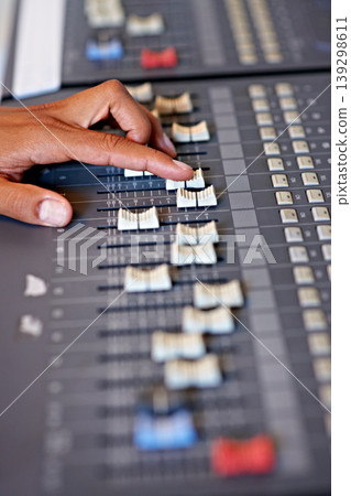 Hand, mixing and sound board in recording studio with dj, technology and media on desk. Music, deck and person editing with equipment for audio, production and moving switch on console for radio song Hand, mixing and sound board in recording studio with dj, technology and media on desk. Music, deck and person editing with equipment for audio, production and moving switch on console for radio song 139298611