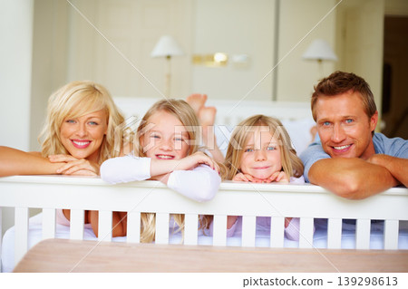 Portrait, love and a family lying on a bed together while in their home on a weekend morning. Face, smile and a happy father, mother and children in the bedroom of an apartment to relax for bonding Portrait, love and a family lying on a bed together while in their home on a weekend morning. Face, smile and a happy father, mother and children in the bedroom of an apartment to relax for bonding 139298613