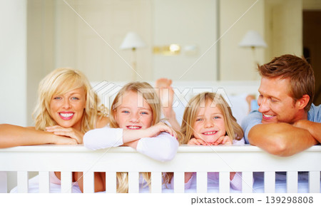 Portrait, happy and a family lying on a bed together while in their home on a weekend morning. Face, love and the smile of a mom, dad and children in the bedroom of an apartment to relax for bonding Portrait, happy and a family lying on a bed together while in their home on a weekend morning. Face, love and the smile of a mom, dad and children in the bedroom of an apartment to relax for bonding 139298808