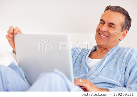 Bathrobe, sofa and mature man on laptop for email, social media or streaming subscription in morning. Internet search, couch and senior person on computer with smile, website or networking in home. Bathrobe, sofa and mature man on laptop for email, social media or streaming subscription in morning. Internet search, couch and senior person on computer with smile, website or networking in home. 139299131