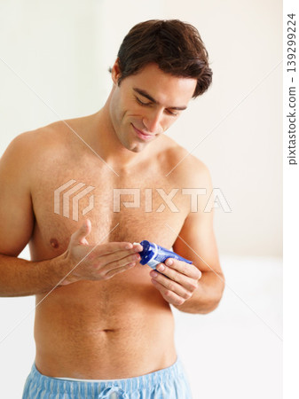 Man, smile and lotion for skincare in bathroom for care, moisturiser or dermatology. Happy person, cosmetology or treatment for wellness, grooming or texture with hydration in morning routine in home Man, smile and lotion for skincare in bathroom for care, moisturiser or dermatology. Happy person, cosmetology or treatment for wellness, grooming or texture with hydration in morning routine in home 139299224