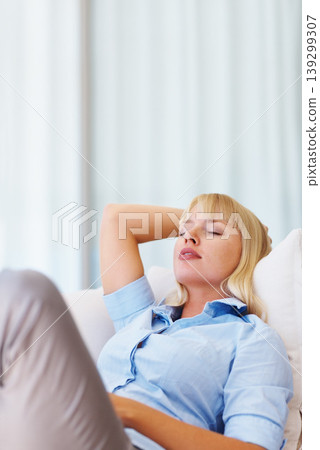 Sleeping, relax and young woman on a sofa for peace after work with tiredness or exhaustion. Calm, rest and female person from Australia taking nap on couch in the living room at modern apartment. 139299307