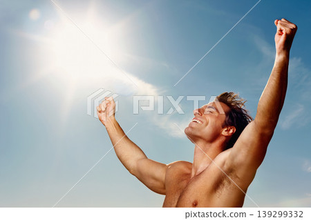 Freedom, hands raised and a shirtless man on a blue sky with flare for fresh air in summer during vacation. Health, fitness and winner with the body of a confident young person outdoor for wellness Freedom, hands raised and a shirtless man on a blue sky with flare for fresh air in summer during vacation. Health, fitness and winner with the body of a confident young person outdoor for wellness 139299332