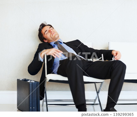 Business man, sleeping and case in airport, chair or fatigue from travel, overworked or burnout in suit. Entrepreneur, briefcase and tired for rest, exhausted or luggage for corporate job with stress Business man, sleeping and case in airport, chair or fatigue from travel, overworked or burnout in suit. Entrepreneur, briefcase and tired for rest, exhausted or luggage for corporate job with stress 139299365