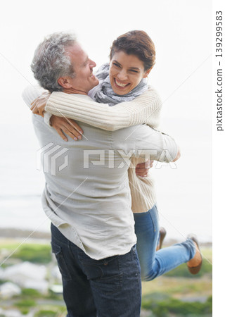 Couple, face and laughing outdoor with hug for romance, love and relationship in nature with date. Mature, man and woman or embrace with happy, playful and trust for bonding, honeymoon and support 139299583
