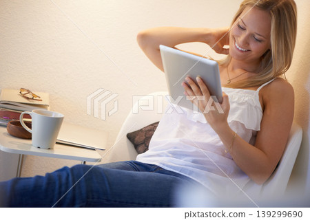 Happy woman, tablet and relax on chair for social media, streaming or entertainment in living room at home. Female person smile with technology for online search, communication or networking at house Happy woman, tablet and relax on chair for social media, streaming or entertainment in living room at home. Female person smile with technology for online search, communication or networking at house 139299690