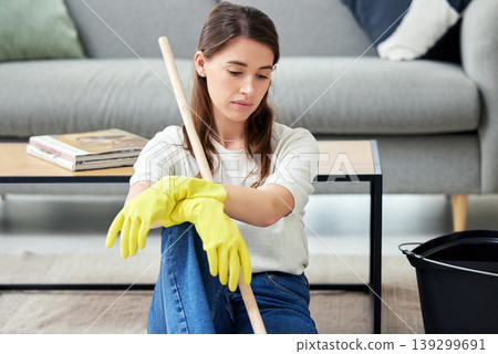 Cleaning, burnout and an unhappy woman in the living room of her home for housework chores. Sad, tired or exhausted with a young person looking bored in her apartment for housekeeping responsibility Cleaning, burnout and an unhappy woman in the living room of her home for housework chores. Sad, tired or exhausted with a young person looking bored in her apartment for housekeeping responsibility 139299691