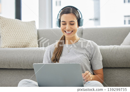Happy, headphones and laptop with woman online in home with remote work, music and living room with smile. Podcast, tech and internet with radio streaming and audio with computer by a sofa with job 139299735
