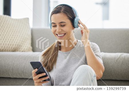 Happy, headphones and phone with woman at home with remote work, music and living room with smile. Podcast, tech and internet with radio streaming and audio with mobile by a sofa with digital job 139299739
