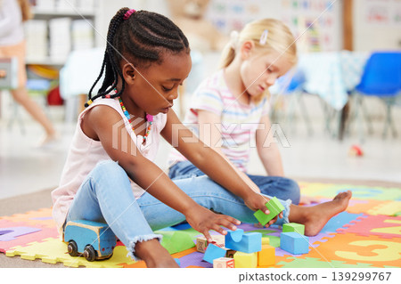 Education, kindergarten and children with toys for playing, child development and creative learning. School, youth and young girls with building blocks for fun, relax and educational games on floor Education, kindergarten and children with toys for playing, child development and creative learning. School, youth and young girls with building blocks for fun, relax and educational games on floor 139299767