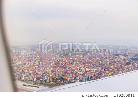 Aerial view of Istanbul city urban landscape with dense buildings through airplane window during flight 139299811