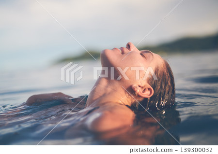 Ocean, swimming and woman with holiday, sea and relax with getaway trip, freedom and outdoor for fun. Person, traveller and girl with vacation, water and summer with weekend break, carefree or travel 139300032