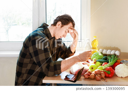 Stressed man looking at a grocery receipt and empty wallet, illustrating high food prices, inflation, and the economic crisis affecting daily shopping expenses. Stressed man looking at a grocery receipt and empty wallet, illustrating high food prices, inflation, and the economic crisis affecting daily shopping expenses. 139300095