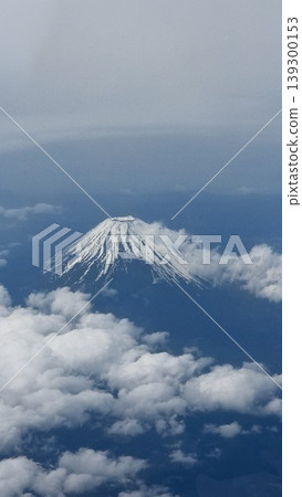 Mount Fuji, with its remaining snow, floating above a sea of clouds, as seen from the window of an airplane. Mount Fuji, with its remaining snow, floating above a sea of clouds, as seen from the window of an airplane. 139300153