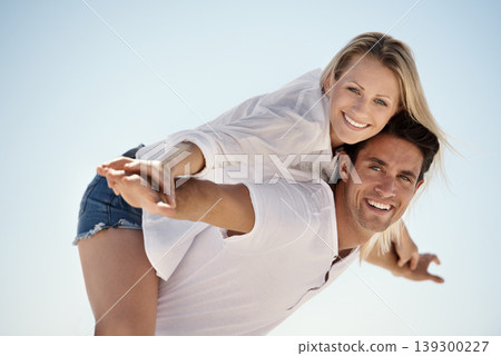 Couple, outdoor and happy for piggy back in portrait, vacation or freedom in summer sunshine for bonding. Man, woman and smile for plane game, care or love by blue sky background on holiday in Napoli Couple, outdoor and happy for piggy back in portrait, vacation or freedom in summer sunshine for bonding. Man, woman and smile for plane game, care or love by blue sky background on holiday in Napoli 139300227