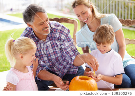 Halloween, family and carving a pumpkin with children outdoor in home backyard for fun and bonding. Man and woman or parents and young kids together for creativity, holiday lantern and happy craft Halloween, family and carving a pumpkin with children outdoor in home backyard for fun and bonding. Man and woman or parents and young kids together for creativity, holiday lantern and happy craft 139300276