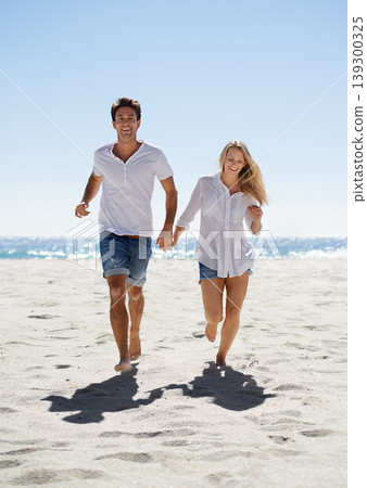 Love, holding hands and happy couple running on beach for date, outdoor bonding and tropical holiday. Romance, man and woman at sea, fun and relax on vacation together with travel, care and adventure 139300325