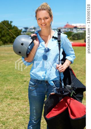 Skydiving, portrait and woman outdoor for adventure with gear and helmet in countryside with a smile. Happy, person and skydiver ready to start, stunt or risk danger with equipment for security 139300328