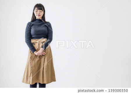 一位年輕女子閉著眼睛站在白色背景前，畫像清晰可見。 139300350