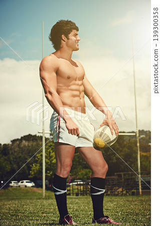 Sports, fitness and rugby man with ball on field for training, wellness and morning cardio outdoor. Handball, exercise and topless male player happy at stadium for competition, action or performance 139300358