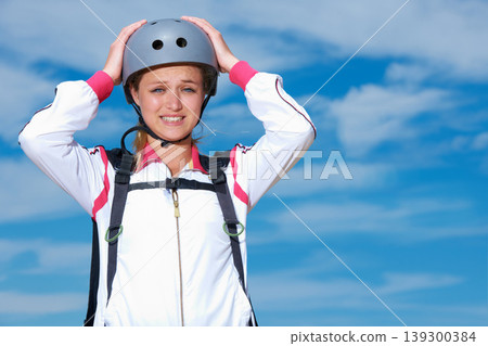Skydiving, worry and portrait of woman on adventure with helmet and anxiety or stress on sky background. Nervous, skydiver and face with fear at the start of stunt in countryside with safety gear 139300384