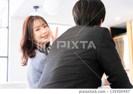 A young woman peeking over a man's shoulder 139300497