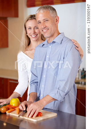 Kitchen, cooking and portrait of couple with vegetables for healthy dinner, lunch and ingredients. Retirement, marriage and mature man and woman cutting food for bonding, help and meal prep at home 139300547