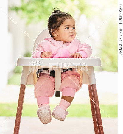 Baby, girl and sitting in feeding chair with thinking, curious and calm expression in home or apartment. Child, kid and relax with comfort, peace and security for development or hungry in house Baby, girl and sitting in feeding chair with thinking, curious and calm expression in home or apartment. Child, kid and relax with comfort, peace and security for development or hungry in house 139300566