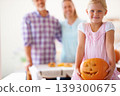 Portrait, child and pumpkin for halloween celebration with parents for fun activity. Jack o lantern, family and little girl looking excited with vegetable and food for season tradition at home 139300675