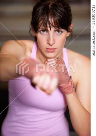 Boxing, punch and portrait of woman with fitness, power and fearless training challenge in gym. Strong body, muscle and face of boxer, athlete or girl with fist up for confidence in competition fight Boxing, punch and portrait of woman with fitness, power and fearless training challenge in gym. Strong body, muscle and face of boxer, athlete or girl with fist up for confidence in competition fight 139300732