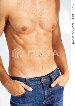 Relax, body and jeans with a man in studio isolated on a white background closeup for masculine style. Fashion, muscle or macho and a cool, shirtless person in denim with his hands in his pockets 139300742