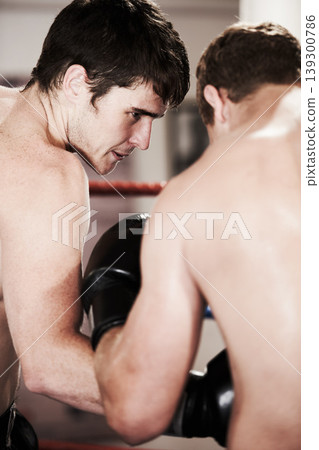 Man, boxing and fight in ring at gym for workout, exercise or indoor self defense training together. Male person, boxer or sports trainer fighting with sparing partner in competition or practice Man, boxing and fight in ring at gym for workout, exercise or indoor self defense training together. Male person, boxer or sports trainer fighting with sparing partner in competition or practice 139300786