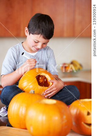 Halloween, pumpkin and boy child in the kitchen for holiday celebration at modern home. Creative, smile and happy young kid bonding and carving vegetable for decoration or tradition at family house. Halloween, pumpkin and boy child in the kitchen for holiday celebration at modern home. Creative, smile and happy young kid bonding and carving vegetable for decoration or tradition at family house. 139300914