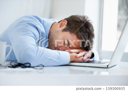 Businessman, laptop and sleeping on office desk in burnout, stress or fatigue from pressure or overworked. Tired man or employee asleep on table with computer in mental health or anxiety at workplace Businessman, laptop and sleeping on office desk in burnout, stress or fatigue from pressure or overworked. Tired man or employee asleep on table with computer in mental health or anxiety at workplace 139300935