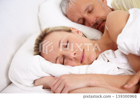 Love, tired and mature couple sleeping in bed for romantic cuddling together on weekend morning. Calm, peaceful and senior man and woman taking a nap in bedroom for bonding at modern apartment. Love, tired and mature couple sleeping in bed for romantic cuddling together on weekend morning. Calm, peaceful and senior man and woman taking a nap in bedroom for bonding at modern apartment. 139300968