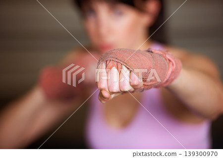 Boxing, punch and hand of woman with fitness, power and fearless training challenge in gym. Strong body, muscle and blurred boxer, athlete or girl with fist up for confidence in competition fight. 139300970