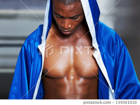 Black man, boxer and champion in robe getting ready for fight, challenge or sports competition at gym or ring. Serious African male person or boxing fighter in preparation for MMA match or game start Black man, boxer and champion in robe getting ready for fight, challenge or sports competition at gym or ring. Serious African male person or boxing fighter in preparation for MMA match or game start 139301010