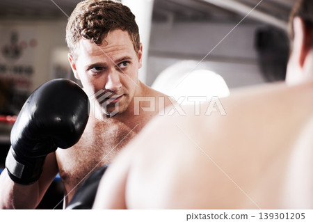 Fight, man and boxer in ring with confidence for fitness, power strike or workout training challenge. Strong hit, boxing and athlete in gym with personal trainer, action and fearless in competition. Fight, man and boxer in ring with confidence for fitness, power strike or workout training challenge. Strong hit, boxing and athlete in gym with personal trainer, action and fearless in competition. 139301205