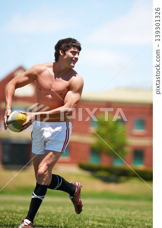 Sports, rugby and fitness man with ball on field for training, wellness and morning cardio outdoor. Handball, exercise and topless male player happy at stadium for competition, action or performance Sports, rugby and fitness man with ball on field for training, wellness and morning cardio outdoor. Handball, exercise and topless male player happy at stadium for competition, action or performance 139301326