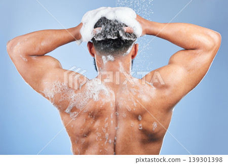 Shower, washing hair and back of man in studio for cleaning, hygiene and skincare on blue background. Dermatology, bathroom and person with shampoo, soap and foam for wellness, health or self care Shower, washing hair and back of man in studio for cleaning, hygiene and skincare on blue background. Dermatology, bathroom and person with shampoo, soap and foam for wellness, health or self care 139301398