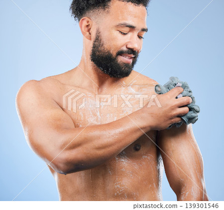 Shower, washing and man with sponge and soap for cleaning, hygiene and skincare on blue background. Dermatology, bathroom and person with splash, foam and cosmetics for wellness or health in studio Shower, washing and man with sponge and soap for cleaning, hygiene and skincare on blue background. Dermatology, bathroom and person with splash, foam and cosmetics for wellness or health in studio 139301546