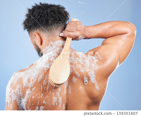 Shower, washing and man with brush and soap in studio for cleaning, hygiene and skincare on blue background. Dermatology, bathroom and person with foam and cosmetics for wellness, health or self care Shower, washing and man with brush and soap in studio for cleaning, hygiene and skincare on blue background. Dermatology, bathroom and person with foam and cosmetics for wellness, health or self care 139301607