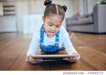 Kid, little girl and tablet for streaming in home with internet for entertainment, learning or watching. Child, youth and lying on floor in living room with technology for online, cartoon or game 139301712
