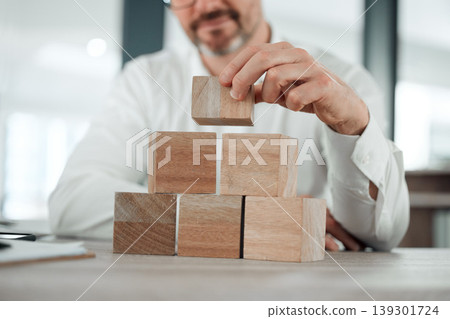 Building blocks, hands and business man in office for future planning, insurance or finance. Wood, puzzle and closeup of male entrepreneur with asset management, investment or financial security Building blocks, hands and business man in office for future planning, insurance or finance. Wood, puzzle and closeup of male entrepreneur with asset management, investment or financial security 139301724