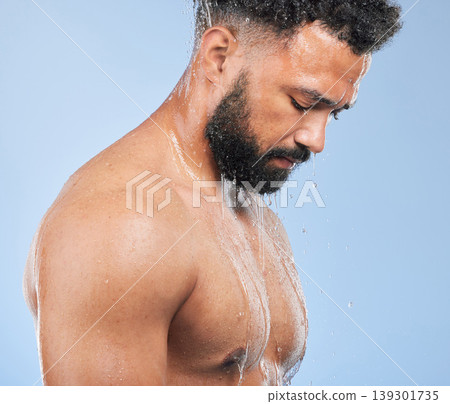 Shower, washing and man with water on blue background for cleaning, hygiene and skincare in studio. Dermatology, bathroom and person with splash, drops and cosmetics for wellness, health or self care 139301735