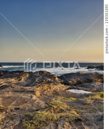 海浪拍打海岸,夕陽西下,海岸風景旖旎。 海浪拍打海岸,夕陽西下,海岸風景旖旎。 139301895