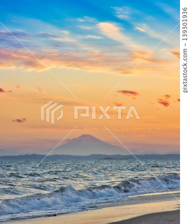 A distant view of Mount Fuji and crashing waves from the beach at sunrise. A distant view of Mount Fuji and crashing waves from the beach at sunrise. 139301936