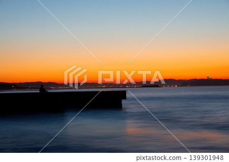 Sunrise at Southern Beach Chigasaki: The tranquil sea and the distant view of Enoshima Island. Sunrise at Southern Beach Chigasaki: The tranquil sea and the distant view of Enoshima Island. 139301948