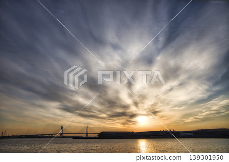 Dawn over Yokohama Port: Sunrise clouds spreading radially, and the Bay Bridge. Dawn over Yokohama Port: Sunrise clouds spreading radially, and the Bay Bridge. 139301950