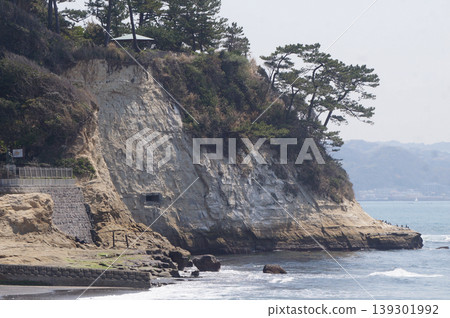 洶湧的白色波浪拍打著陡峭的懸崖和深藍色的大海。 洶湧的白色波浪拍打著陡峭的懸崖和深藍色的大海。 139301992